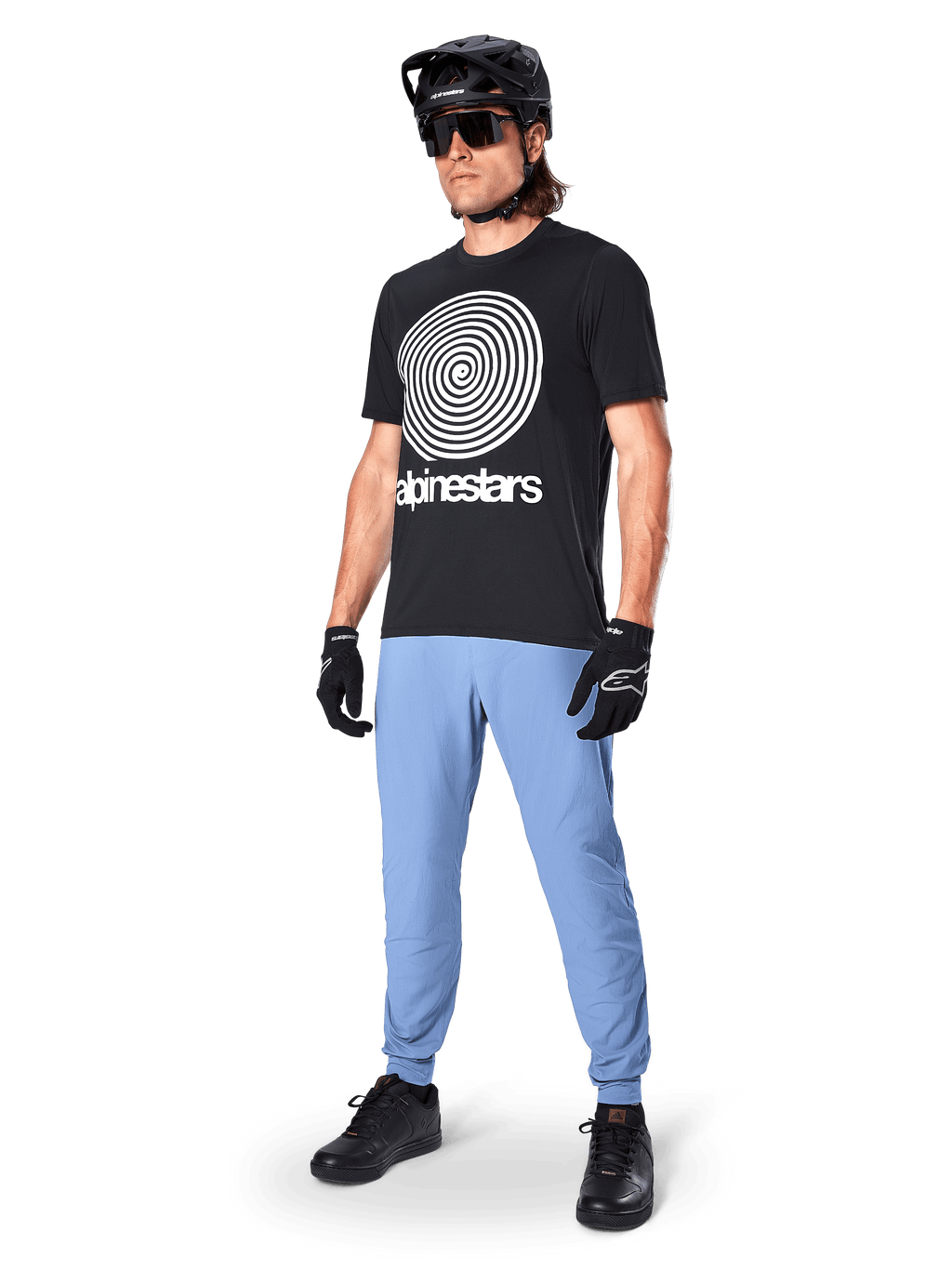 Calças Alpinestars A-Dura, calças de MTB, Azul Infinity, usadas com t-shirt gráfica preta com logótipo em espiral branco, capacete preto, óculos de sol e luvas pretas, equipamento profissional de MTB