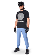 Calças Alpinestars A-Dura, calças de MTB, Azul Infinity, usadas com t-shirt gráfica preta com logótipo em espiral branco, capacete preto, óculos de sol e luvas pretas, equipamento profissional de MTB