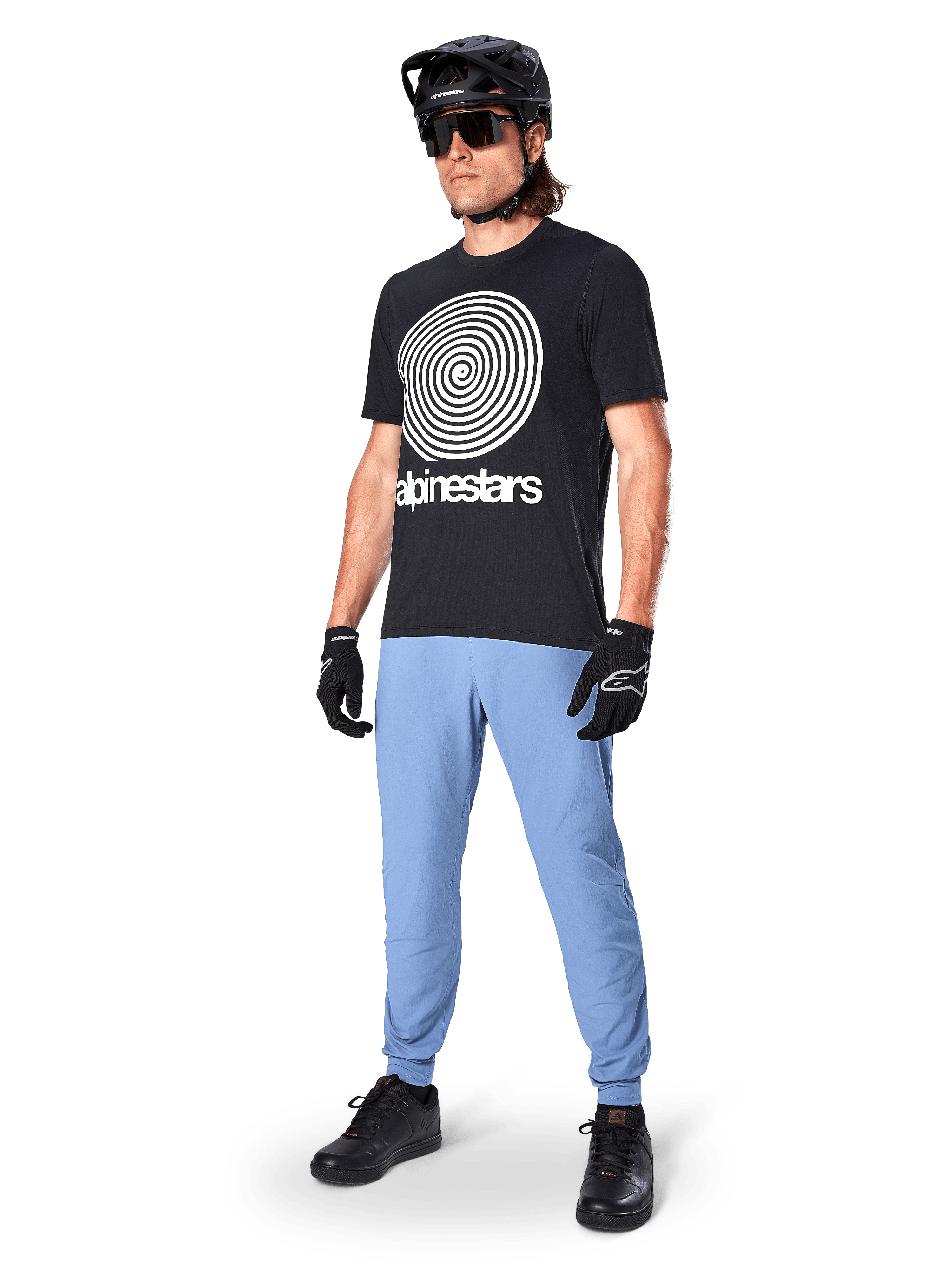 Calças Alpinestars A-Dura, calças de MTB, Azul Infinity, usadas com t-shirt gráfica preta com logótipo em espiral branco, capacete preto, óculos de sol e luvas pretas, equipamento profissional de MTB