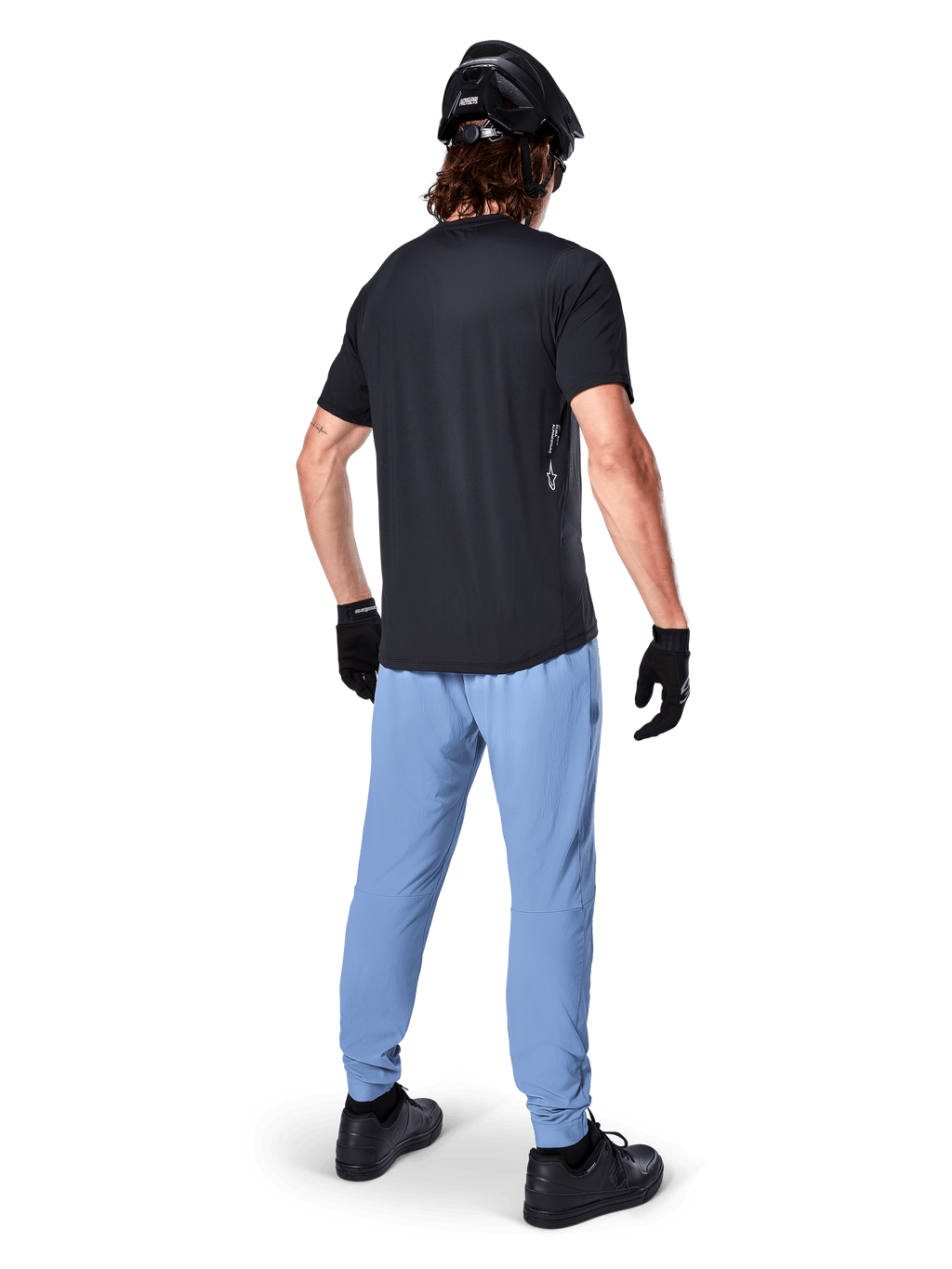 Calças Alpinestars A-Dura, calças de BTT, Infinity Blue, vista traseira de modelo a usar t-shirt preta e capacete de ciclismo preto, com tecido elástico em 2 direções durável e punhos elásticos, equipamento de performance para BTT