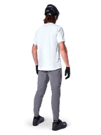 Calças Alpinestars A-Dura, calças de BTT em cinzento escuro vistas de trás, usadas com uma t-shirt branca de manga curta, capacete de BTT preto, luvas e sapatos pretos, design de corte regular com punhos elásticos, equipamento de ciclismo todo-o-terreno durável