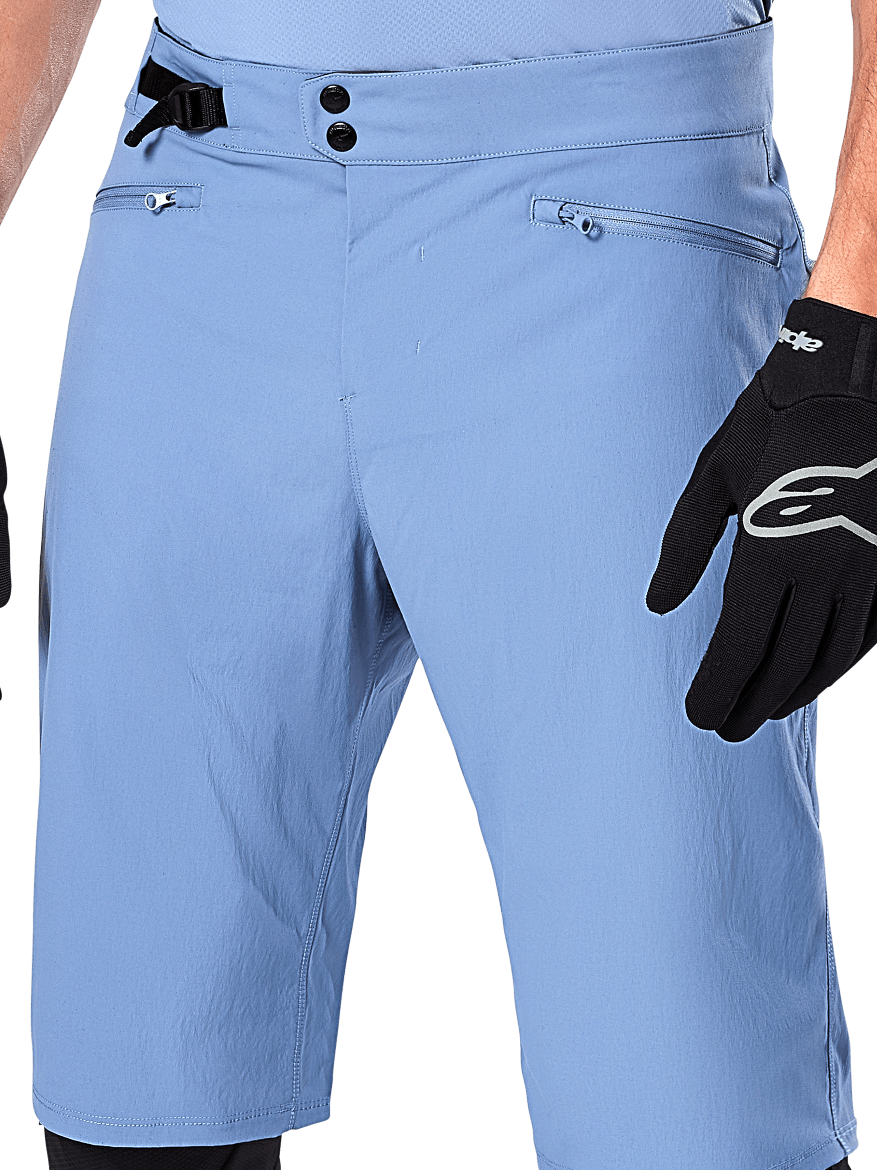 Calções Alpinestars A-Dura, calções de BTT em azul Infinity, grande plano da cintura com fecho de pressão duplo, ajuste lateral regulável e bolsos com fecho e forro em rede, usados com uma luva Alpinestars preta