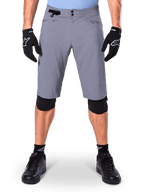 Calções Alpinestars A-Dura, calções de mountain bike, cinzento-escuro, usados com luvas e joelheiras pretas Alpinestars, com fecho duplo de pressão e bolsos com fecho e forro em rede, tecido durável com elasticidade bidirecional para ciclismo fora de estrada