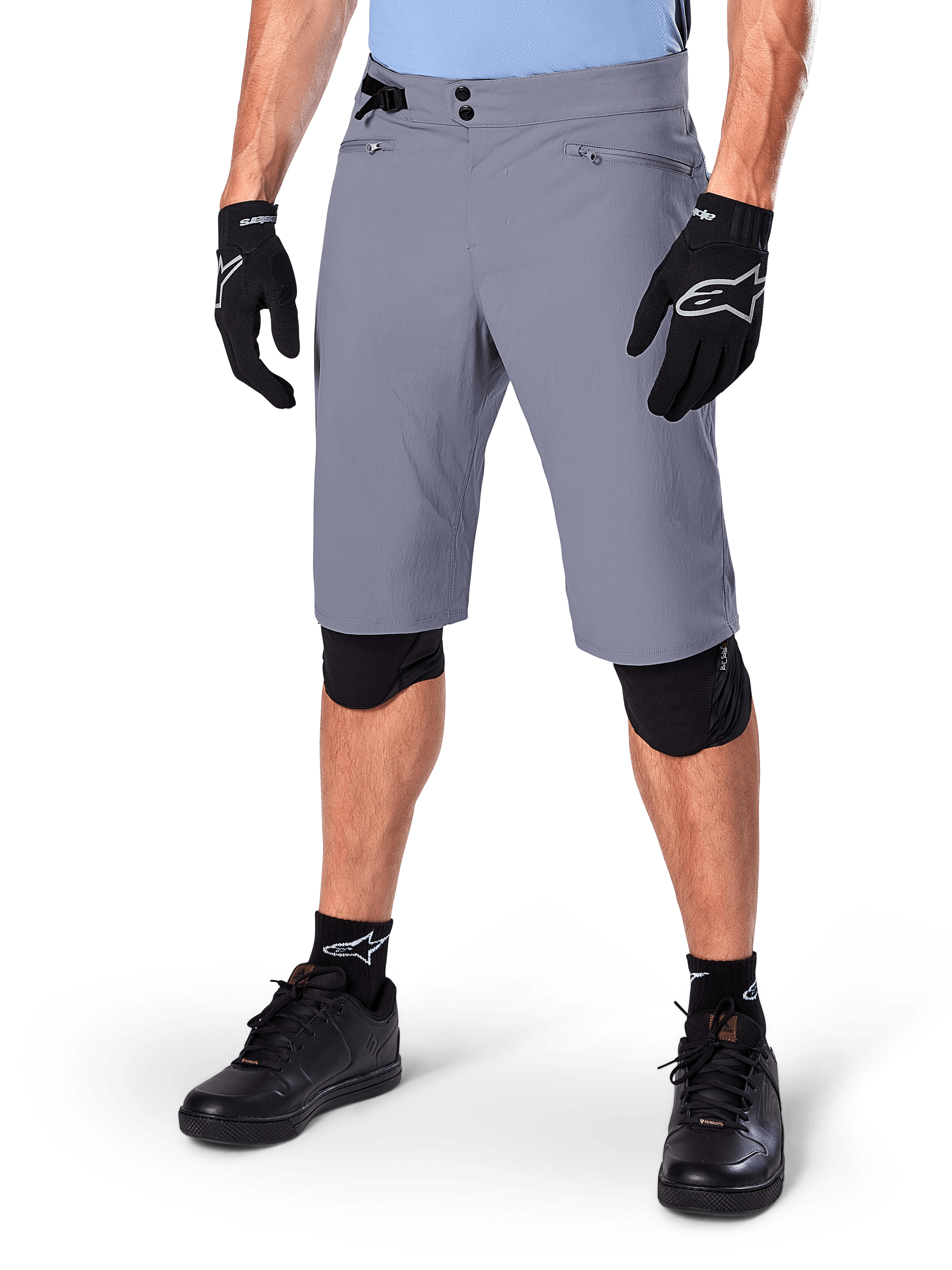 Alpinestars A-Dura Shorts, calções de BTT cinzento escuro, combinados com luvas pretas e joelheiras, com bolsos com fecho de correr e fecho de pressão duplo, equipamento de ciclismo robusto para trilhos fora de estrada