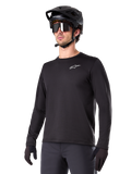 Alpinestars A-Dura Thermal Jersey, Black long-sleeve mountain bike jersey, white chest logo, worn with black helmet and gloves, sleek sporty design for trail riding