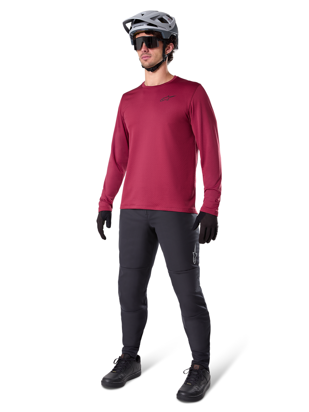 Alpinestars A-Dura Thermal Jersey em borgonha, camisola de ciclismo de manga comprida com isolamento térmico, combinada com calças de BTT cinzento-escuro, luvas pretas e um capacete cinzento, fotografia de estúdio de corpo inteiro de equipamento de BTT para tempo frio.