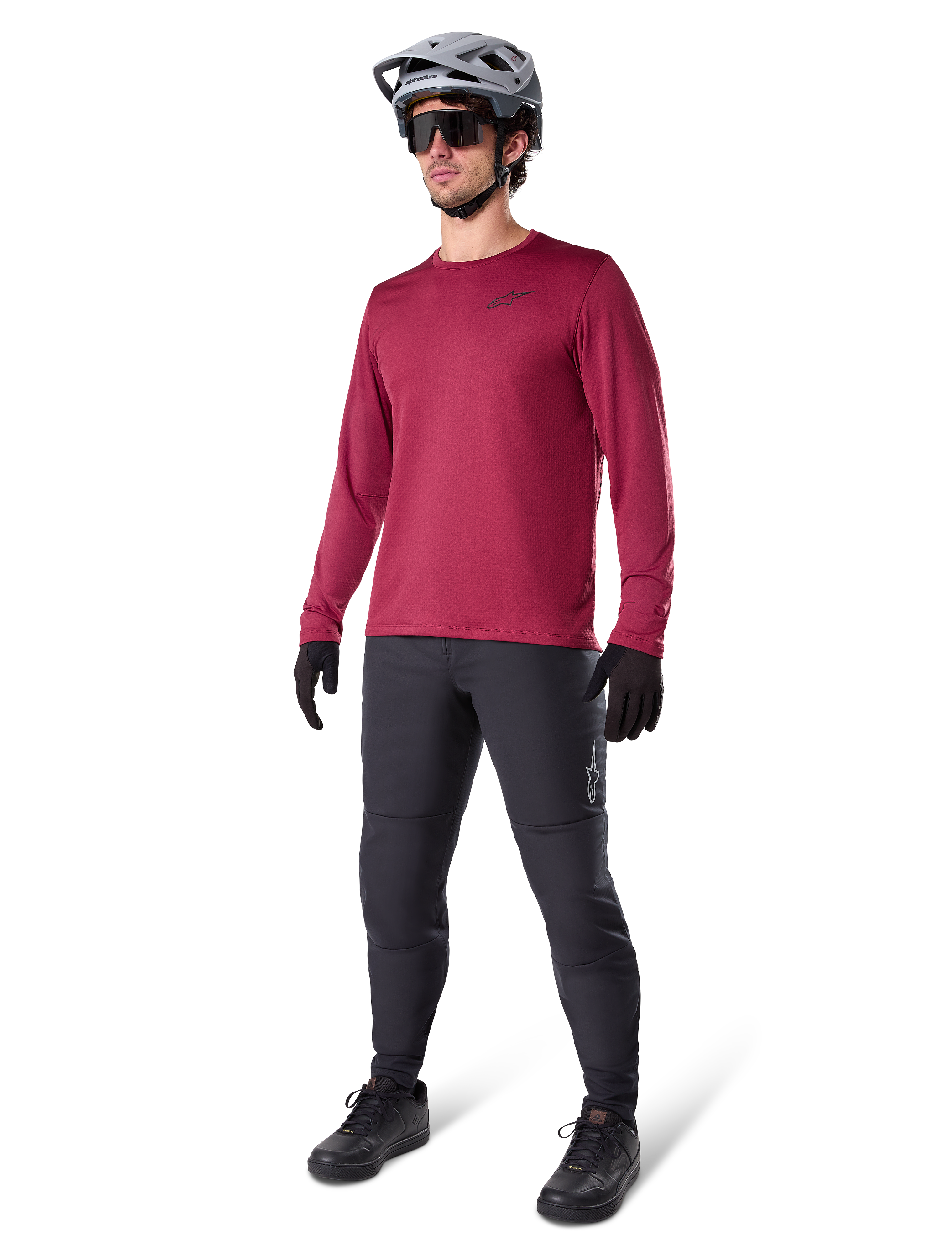 Alpinestars A-Dura Thermal Jersey em borgonha, camisola de ciclismo de manga comprida com isolamento térmico, combinada com calças de BTT cinzento-escuro, luvas pretas e um capacete cinzento, fotografia de estúdio de corpo inteiro de equipamento de BTT para tempo frio.