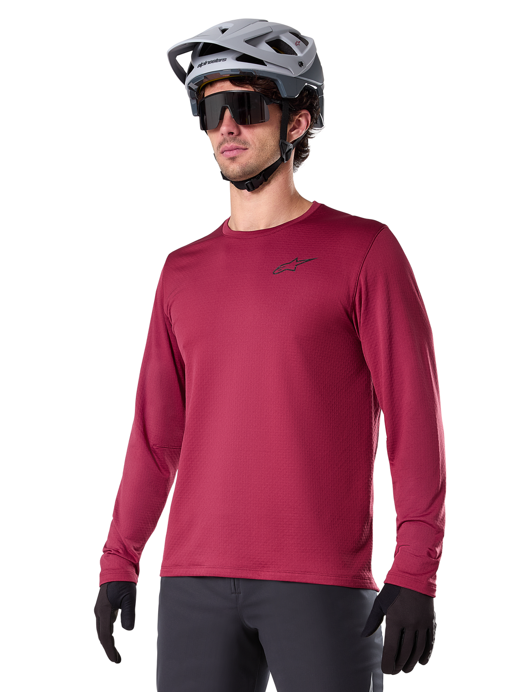 Alpinestars A-Dura Thermal Jersey, camisola de ciclismo de montanha de manga comprida, vermelho bordeaux, com forro de lã isolante e um pequeno logótipo preto no peito, usada com capacete cinzento, óculos de sol pretos e luvas pretas, concebida para ciclismo em tempo frio