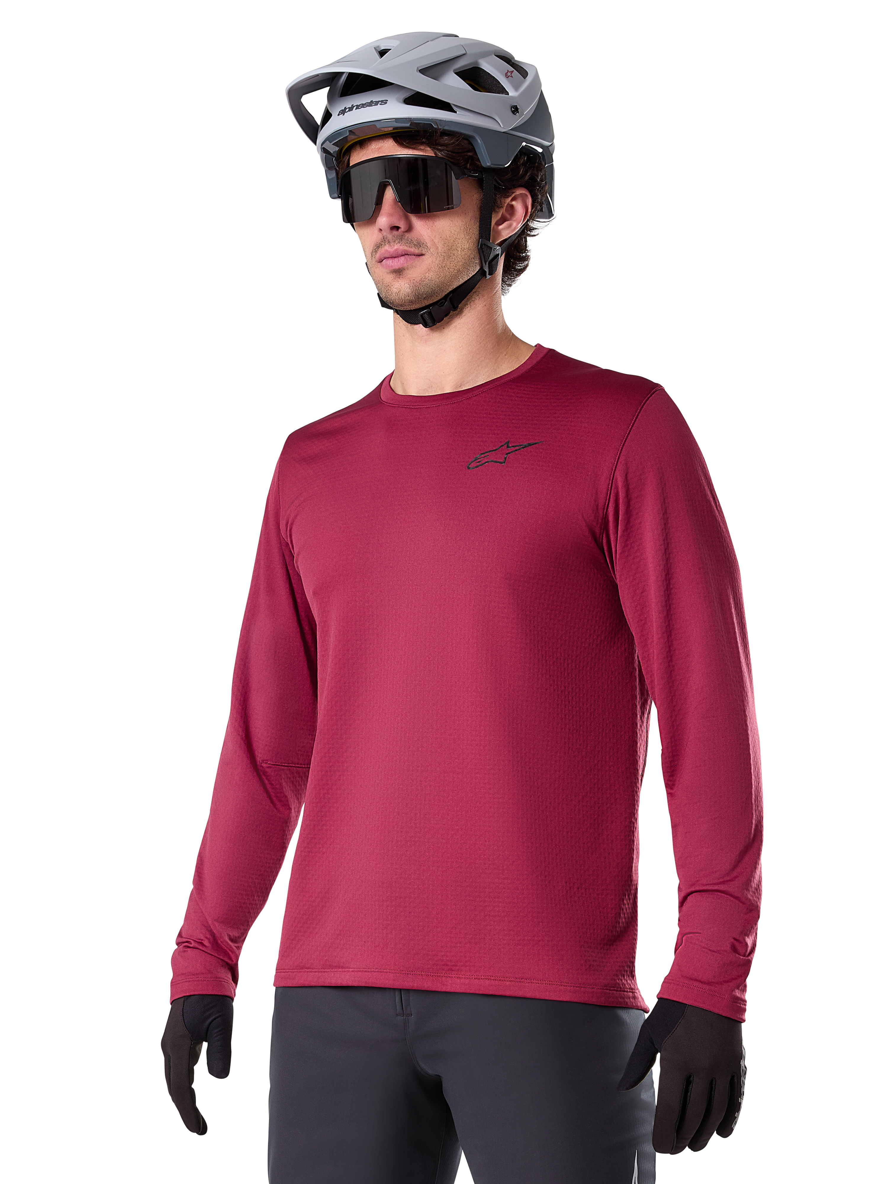 Alpinestars A-Dura Thermal Jersey, camisola de ciclismo de montanha de manga comprida, vermelho bordeaux, com forro de lã isolante e um pequeno logótipo preto no peito, usada com capacete cinzento, óculos de sol pretos e luvas pretas, concebida para ciclismo em tempo frio