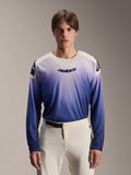 Alpinestars A-Aria Polartec Maker Elite Jersey, camisola de manga comprida para BTT, Baja Blue com gradiente de branco para azul, usada por um modelo com calças brancas, com logótipo azul escuro no peito e perfurações a laser nas mangas, vestuário de performance para ciclismo de montanha