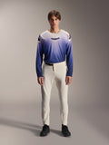 Alpinestars A-Aria Elite Pants, calças de performance para MTB em cor cru, calças de ciclismo off-white com painéis perfurados a laser nas coxas e fivela magnética, combinadas com camisola de manga comprida em azul degradê e sapatos pretos, ajuste de performance para trilhos