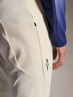 Alpinestars A-Aria Elite Pants, calças de performance em branco sujo (ecru), vista em grande plano de bolso lateral com fecho e perfurações a laser para ventilação, detalhe de logótipo minimalista, tecido de elevada elasticidade para BTT