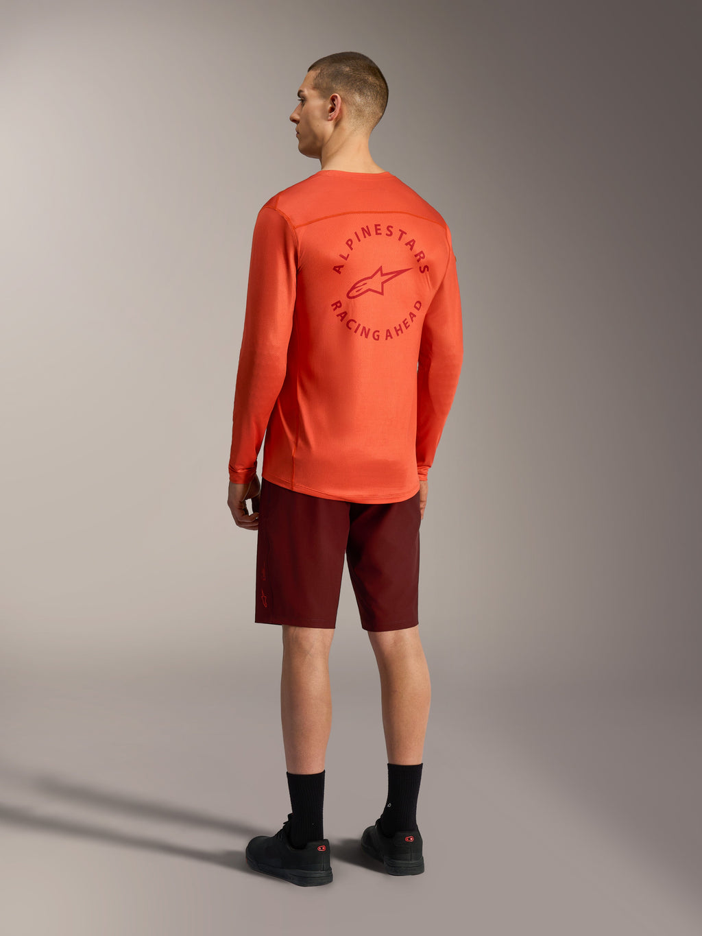 Jersey de manga comprida A-Dura Air laranja e calções A-Dura Ride bordeaux, equipamento de BTT com gráfico nas costas.