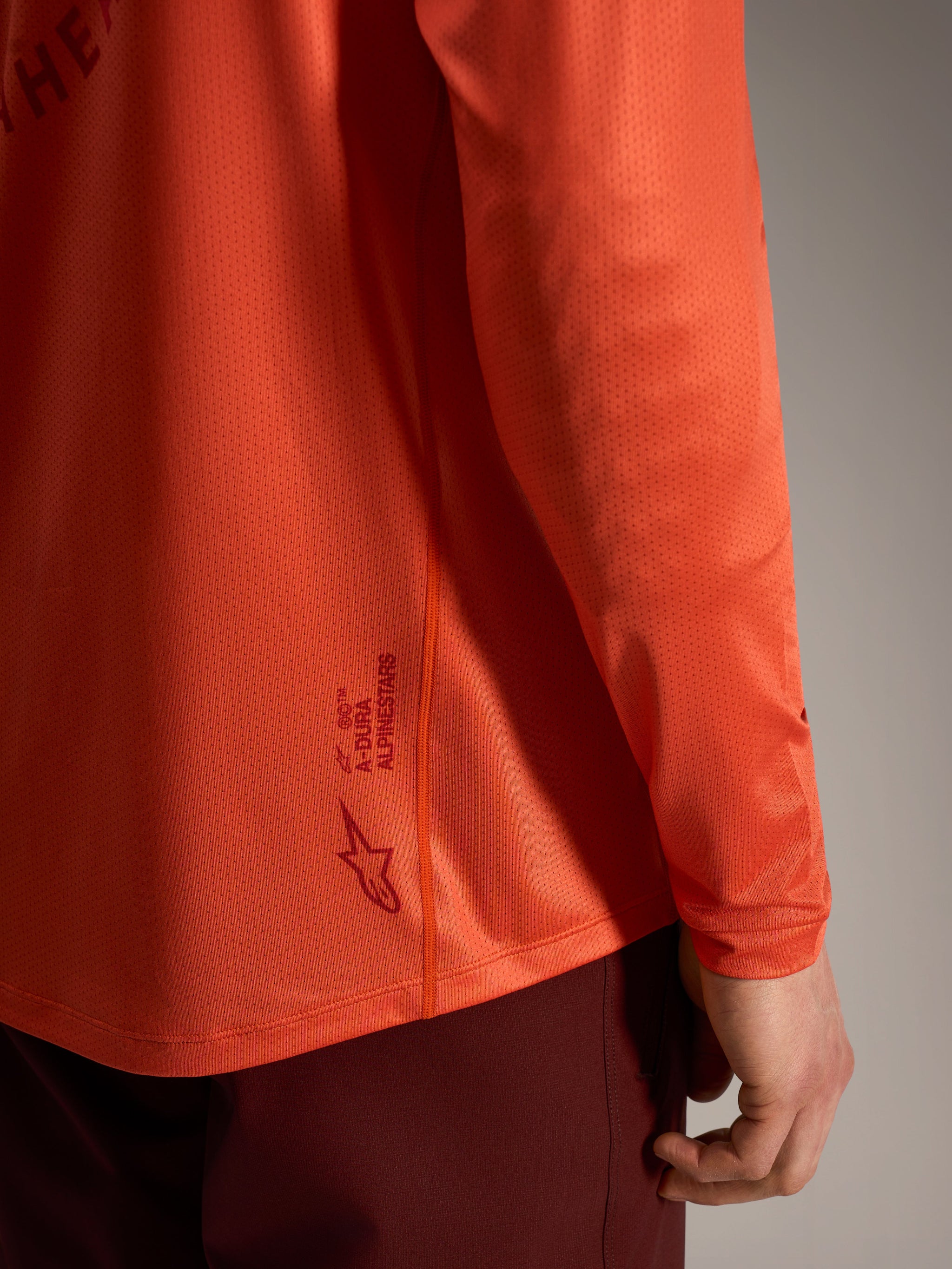 Camisola Alpinestars A-Dura Air laranja, manga comprida em malha respirável com detalhe do logótipo nas costas.