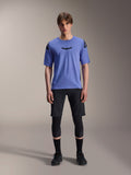 Alpinestars A-Aria Elite Shorts, calções de BTT, Black Titanium, usados com camisola azul de manga curta, joelheiras e sapatos de ciclismo pretos, fotografia de corpo inteiro em estúdio, vestuário de performance para BTT