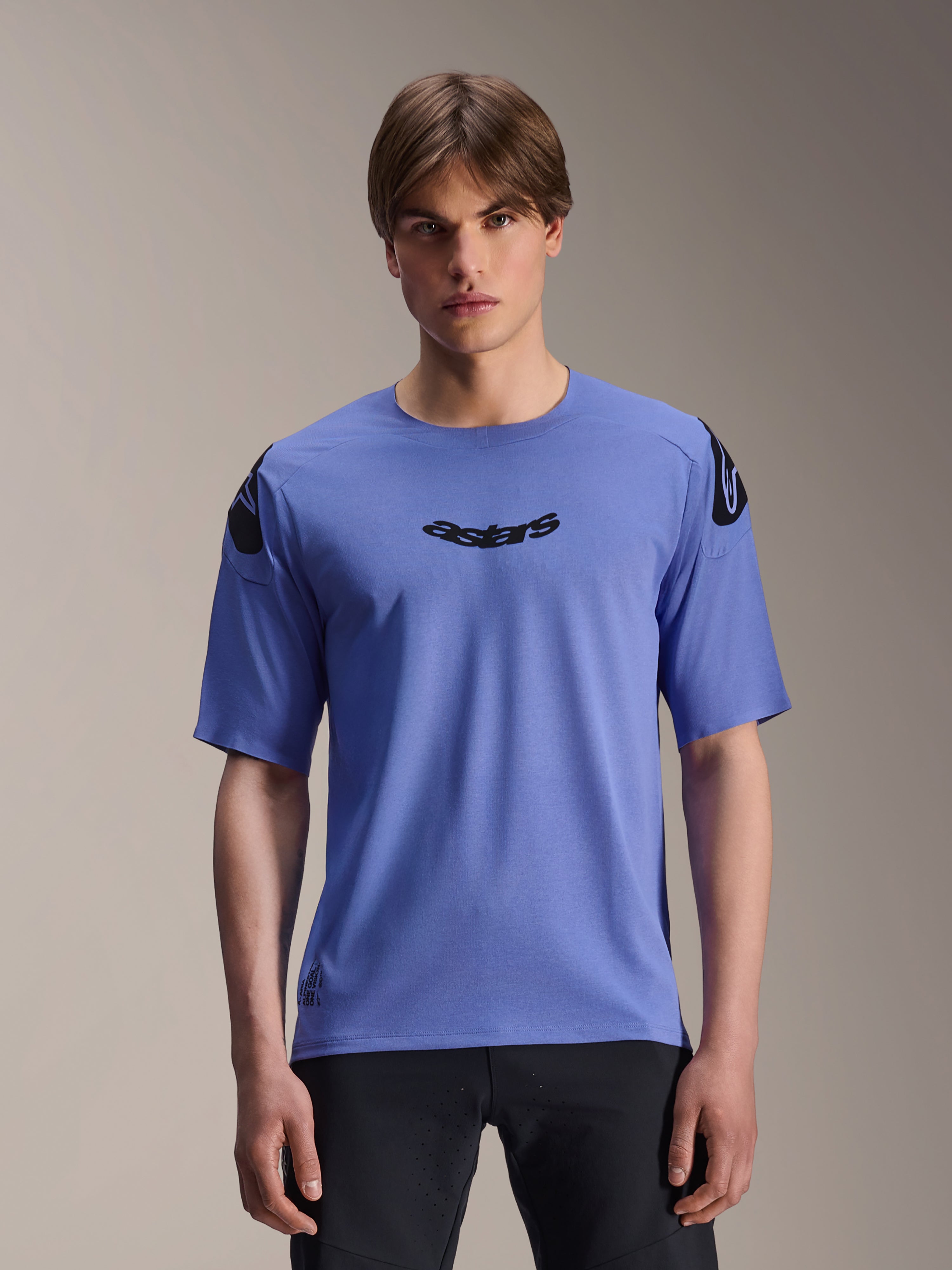 Alpinestars A-Aria Polartec Elite Jersey, camisola de MTB de manga curta, cor azul Baja, vestida por um modelo masculino, com logótipo 'astars' preto no peito e logótipos nos ombros, vestuário de performance para trilhos.