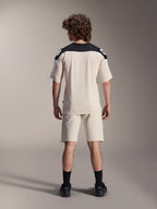 Alpinestars A-Aria Elite Shorts and A-Aria Polartec Elite SS Jersey, Ecru with black shoulder panels, rear view of a model in mountain bike performance gear, styled with black socks and shoes