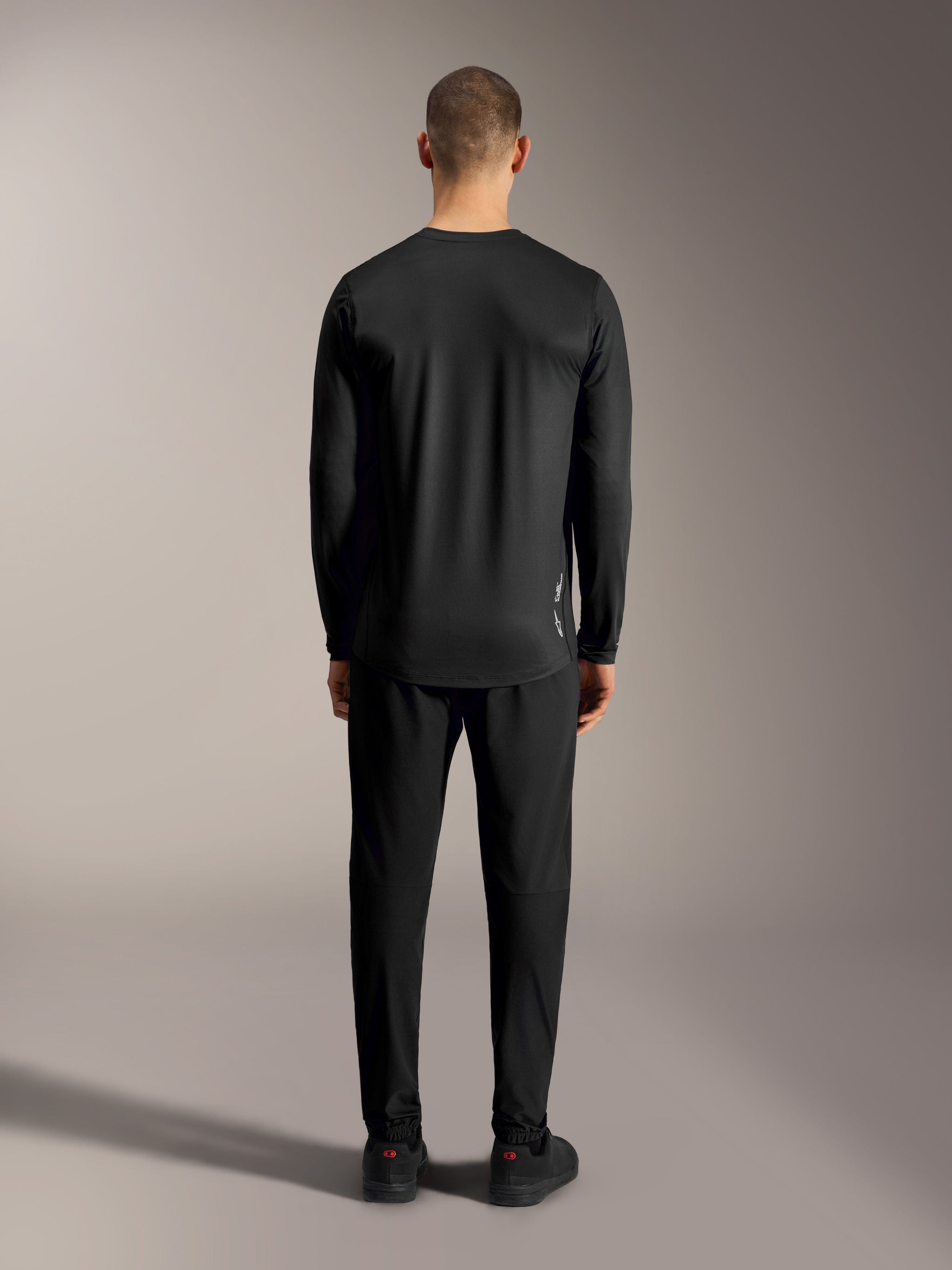 Black A-Dura Ride Long Sleeve Jersey, back view highlighting the drop tail and stretch fabric for MTB performance.