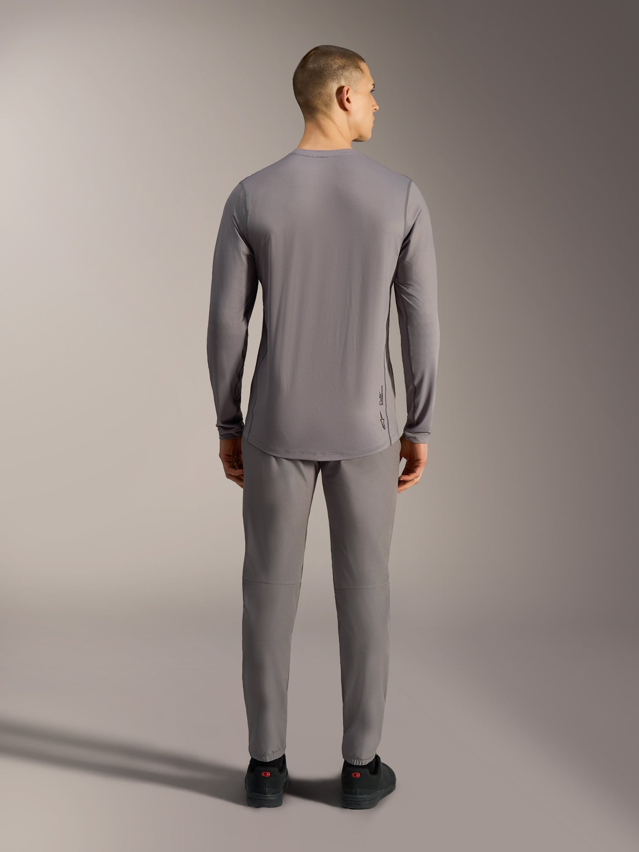 Camisola Alpinestars A-Dura Ride cinzenta, topo de BTT em tecido jacquard elástico com mangas compridas e cauda mais longa.