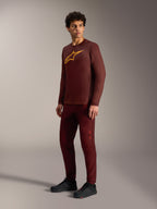 Camisola A-Dura Ride bordeaux de manga comprida, logótipo amarelo, calças a condizer e sapatilhas de ciclismo pretas.