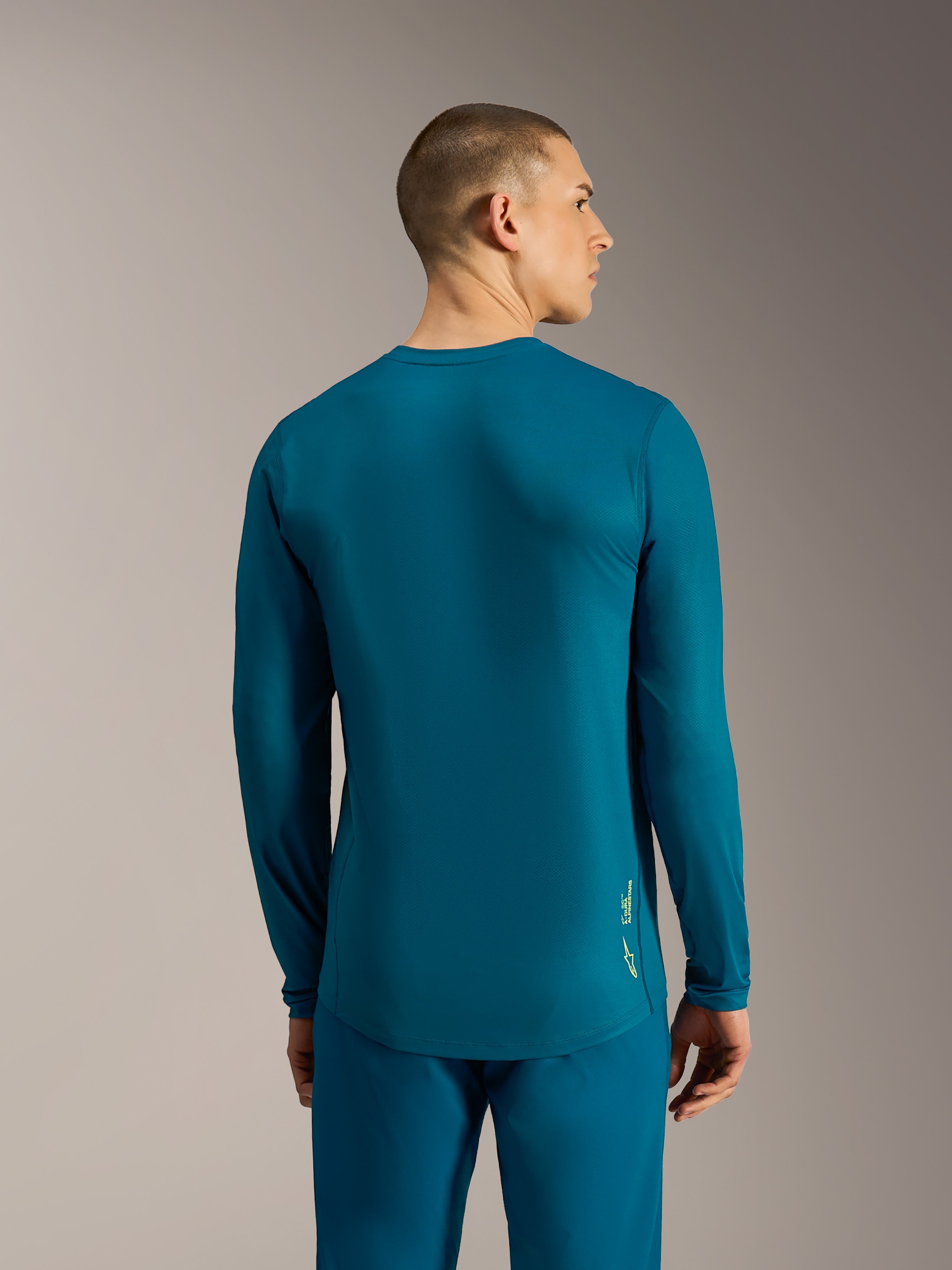 Jersey Alpinestars A-Dura Ride mangas compridas, azul esverdeado, cauda longa e logótipo para performance em BTT.