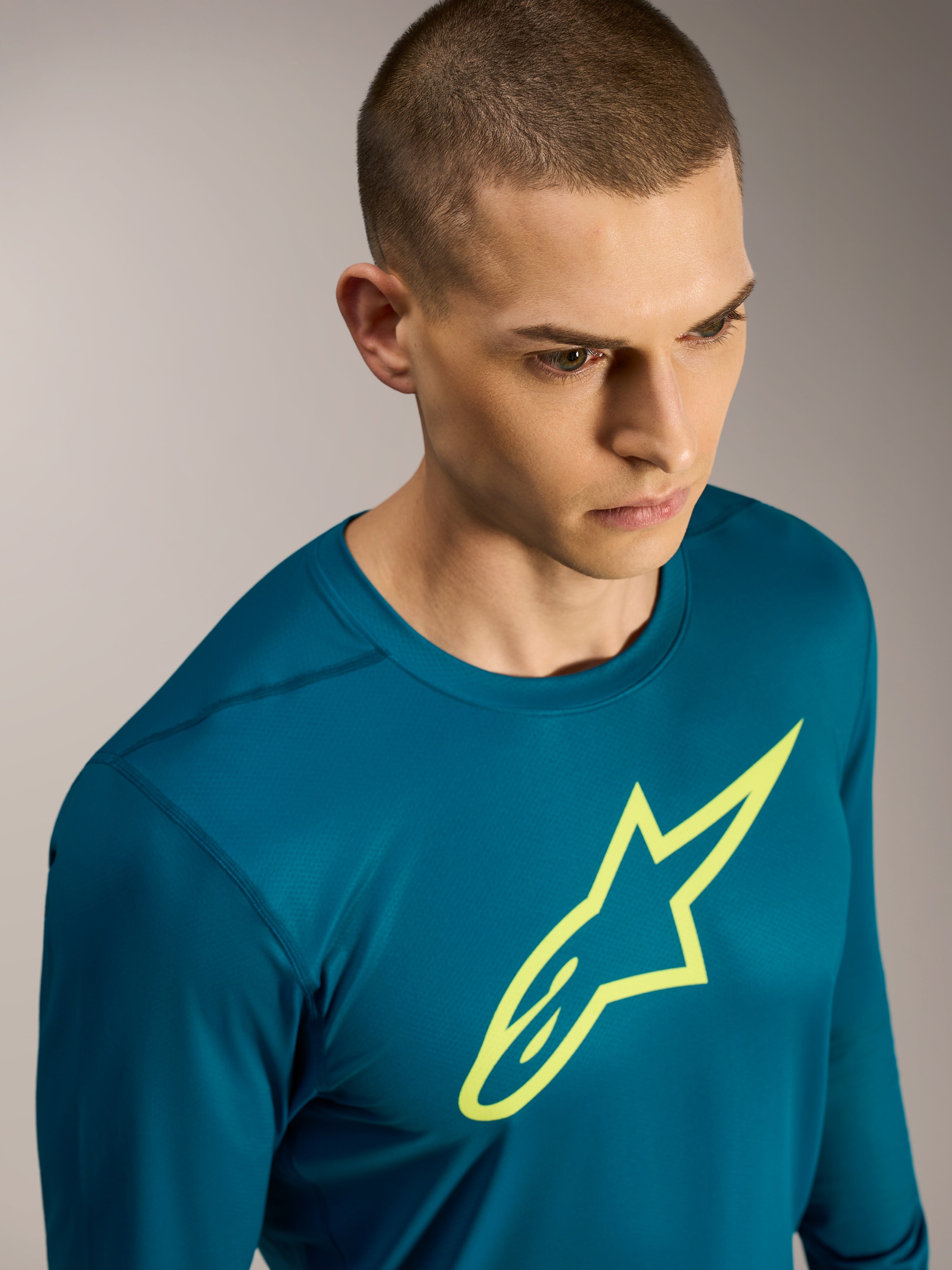 Jersey Alpinestars A-Dura Ride azul-esverdeado, mangas compridas com logótipo amarelo e tecido elástico de performance.