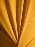 Pormenor da textura cor de laranja da camisola A-Dura Ride em material leve de jacquard poliéster e spandex.