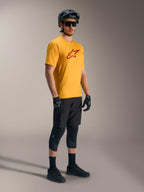 Camisola A-Dura Ride de mangas curtas laranja com logótipo Astars vermelho, equipamento de BTT preto e capacete.