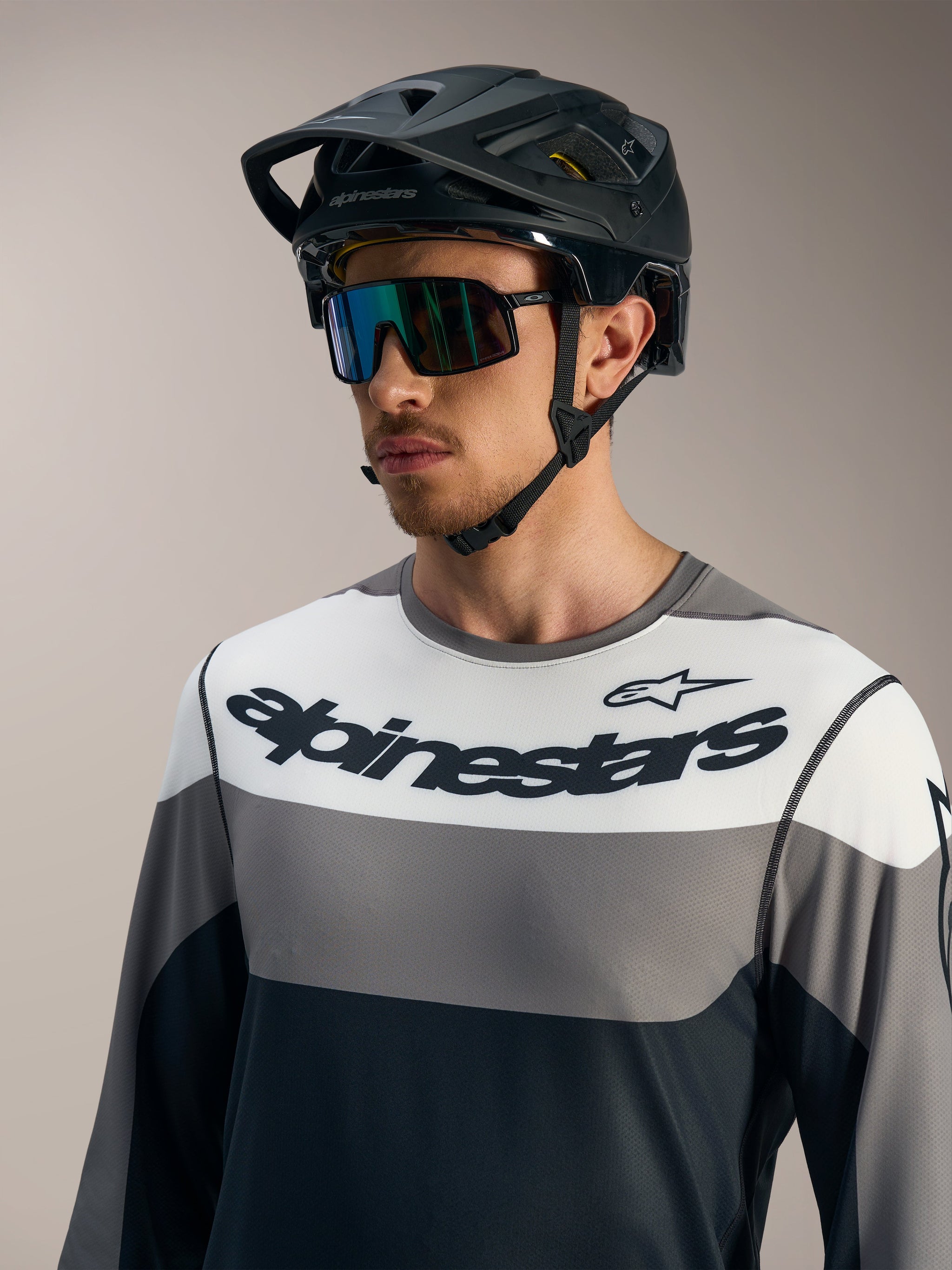 Camisola Alpinestars A-Dura Race cinzenta com design color-block, mangas compridas e capacete de BTT preto.