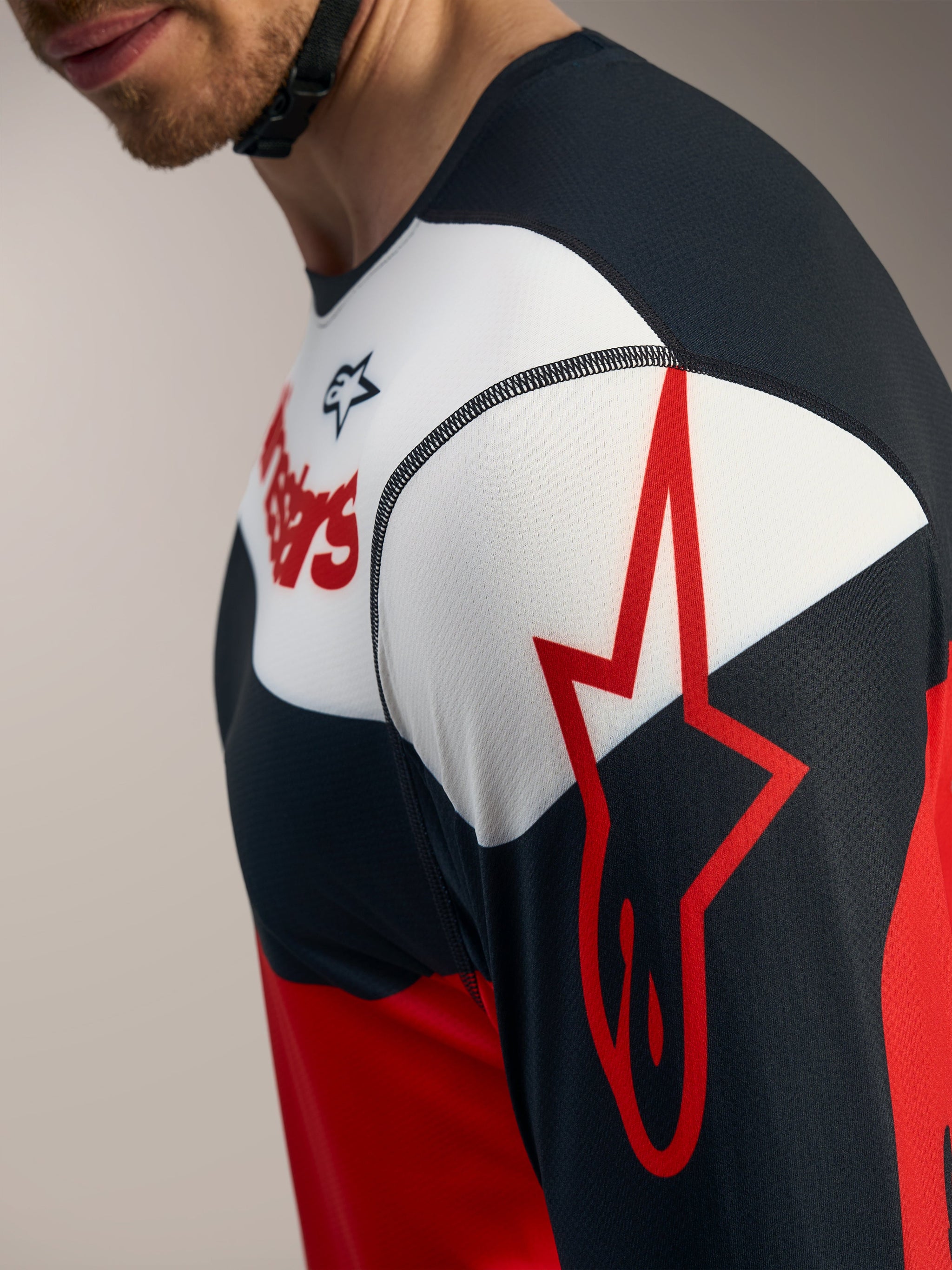Camisola A-Dura Race Alpinestars em vermelho, preto e branco, com detalhe do logótipo de estrela na manga.