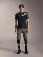 Alpinestars A-Dura Lipan Short Sleeve Jersey, preta com mangas em cinzento mesclado e logótipo Astars bege no peito, vestida por um modelo masculino com calções de BTT cinzentos e joelheiras pretas, equipamento de performance para MTB