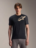 Modelo masculino a usar Jersey de Manga Curta Alpinestars A-Dura Lipan, camisola de BTT preta com logótipo de estrela bege e mangas cinzentas escuras, combinada com calças de ciclismo cinzentas, vestuário de performance casual