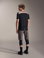 Alpinestars A-Dura Lipan Jersey de Manga Curta em preto, vista traseira no modelo a destacar o painel de malha perfurada castanho claro na parte superior das costas, combinada com calções de BTT cinzentos e joelheiras pretas, conjunto de trail completo.