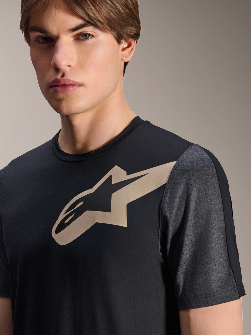Camisola Alpinestars A-Dura Lipan - Manga Curta, preta, com um logótipo Astars bege no peito e mangas perfuradas em cinzento escuro mesclado, vestuário de performance para bicicleta de montanha