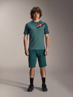 Camisola Alpinestars A-Dura Lipan, camisola de BTT de manga curta, verde Silver Pine com logótipo Astars em preto e laranja no peito, combinada com calções a condizer e calçado preto, equipamento técnico de BTT
