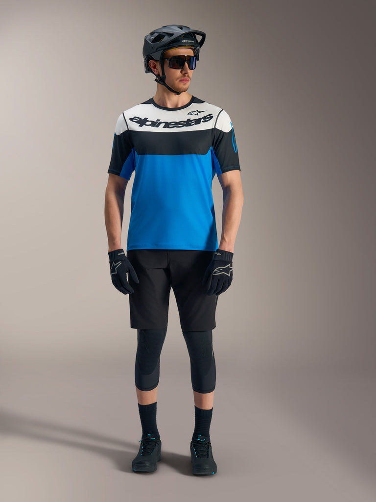 Alpinestars A-Dura Race SS Jersey and Ride Shorts, blue and black mountain bike gear with protective helmet and guards.
