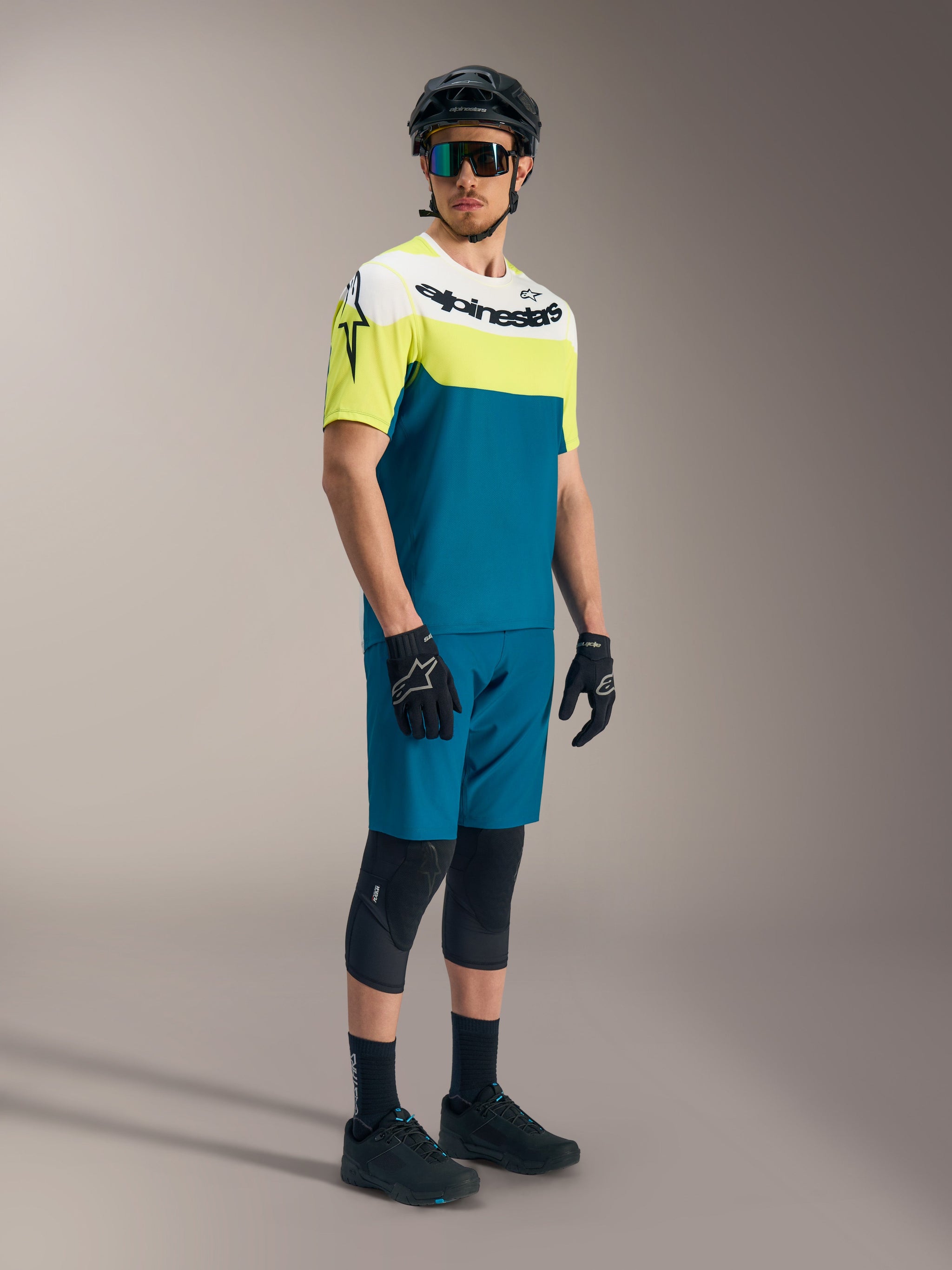 A-Dura Race Short Sleeve Jersey in white, lime, and blue green with Alpinestars branding, paired with MTB cycling gear.