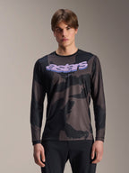 Alpinestars A-Dura Hollow Camo Jersey de manga comprida, camisola de BTT, padrão camuflado preto e cinzento, gráfico 'astars' roxo no peito, modelo com calças pretas, design casual de performance