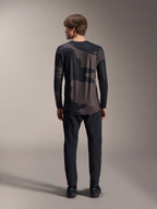 Alpinestars A-Dura Hollow Camo Long Sleeve Jersey, Black Camo, vista traseira vestida com calças pretas, com um padrão de camuflagem escuro e bainha traseira alongada para cobertura em BTT.