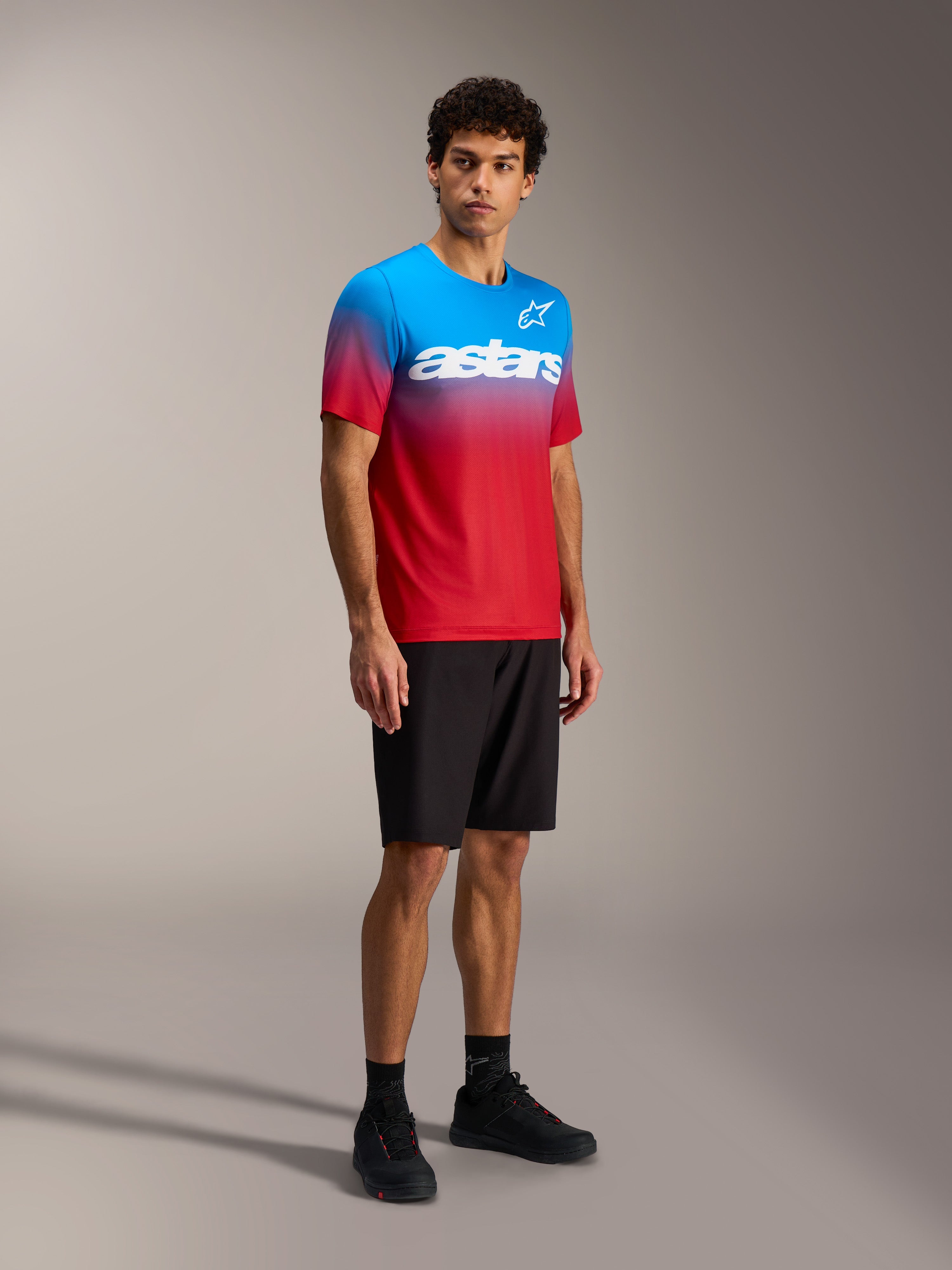 Camisola Alpinestars A-Dura ASTARS 2.0, gradiente azul e vermelho, manga curta MTB com logótipo branco no peito.