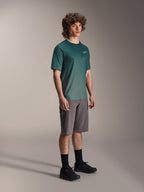 Alpinestars A-Dura Rise Jersey - Short Sleeve in Silver Pine, green mountain bike jersey worn by a model with grey shorts and black sneakers, casual MTB trail riding gear featuring a small white chest logo
