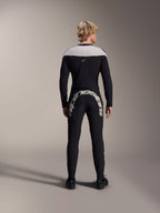 Homem visto de costas a usar a Camisola de Manga Comprida Alpinestars A-Supra Melt em preto, com painel nos ombros em cinzento claro, combinada com calças de BTT pretas com um logótipo Alpinestars grande na parte traseira, kit de performance para mountain bike