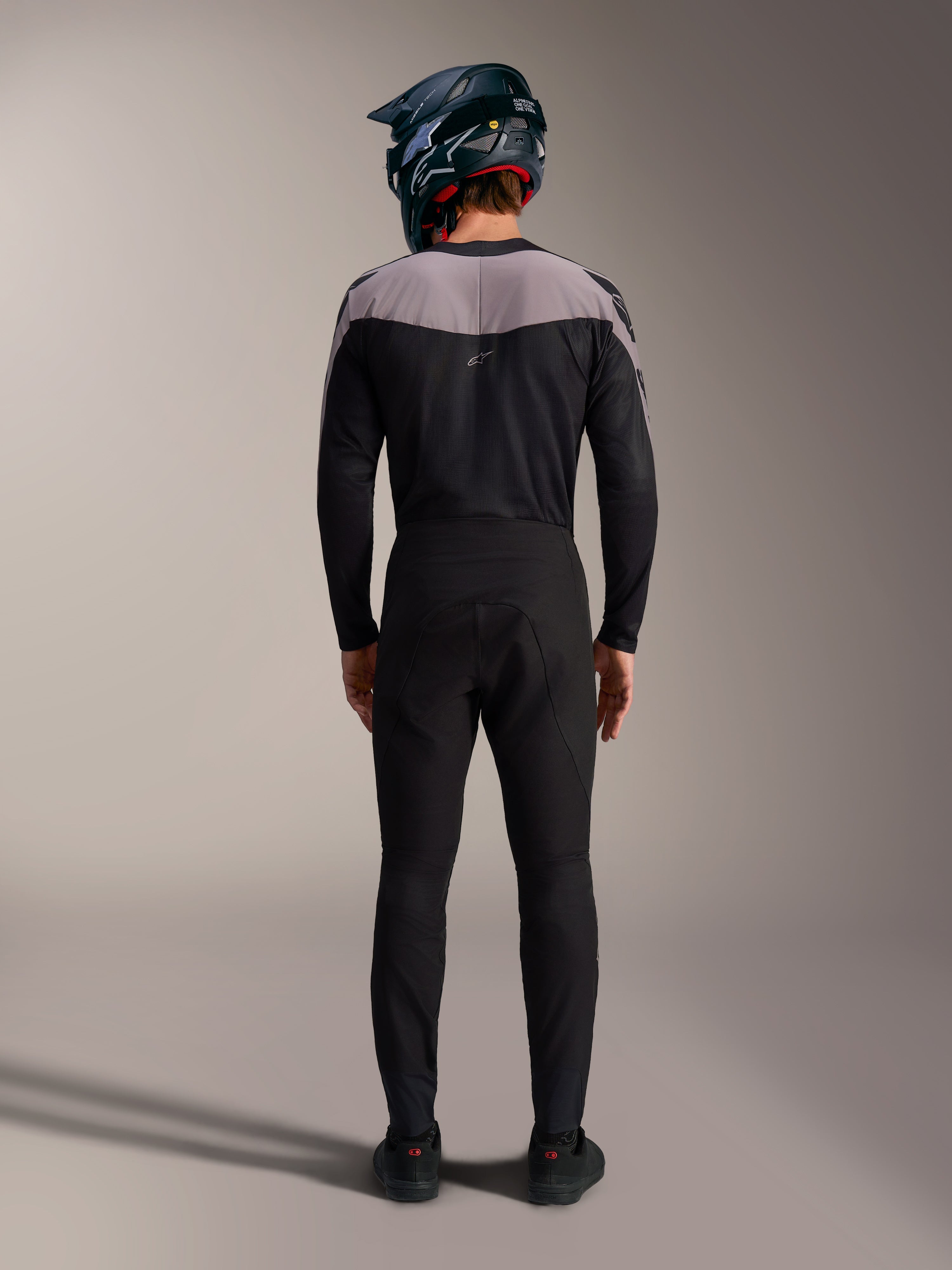 Kit BTT Alpinestars A-Supra Elite preto, camisola e calças de alta performance com capacete integral, vista traseira.