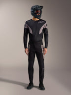 Kit de BTT A-Supra Elite preto, camisola de manga comprida e calças com logótipos cinzentos e capacete integral.
