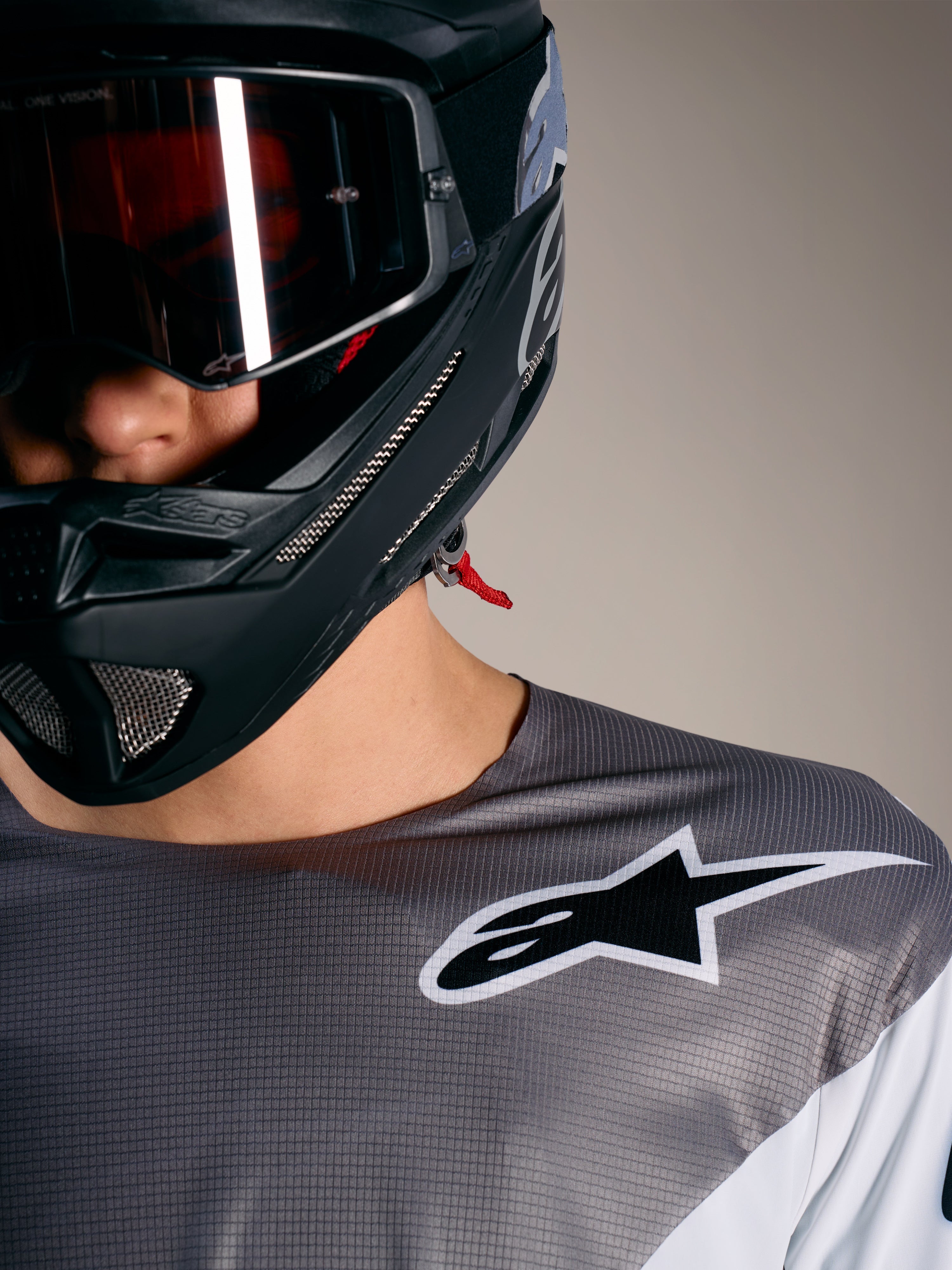 Camisola Alpinestars A-Supra Elite em cinzento degradê, logótipo branco, tecido microperfurado e capacete de BTT preto