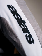 Camisola A-Supra Elite em cinzento, tecido microperfurado com logótipo ASTARS preto sobre banda branca na manga.