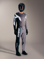 Camisola A-Supra Elite cinzento desbotado com detalhes preto e branco, num piloto com equipamento completo de BTT.