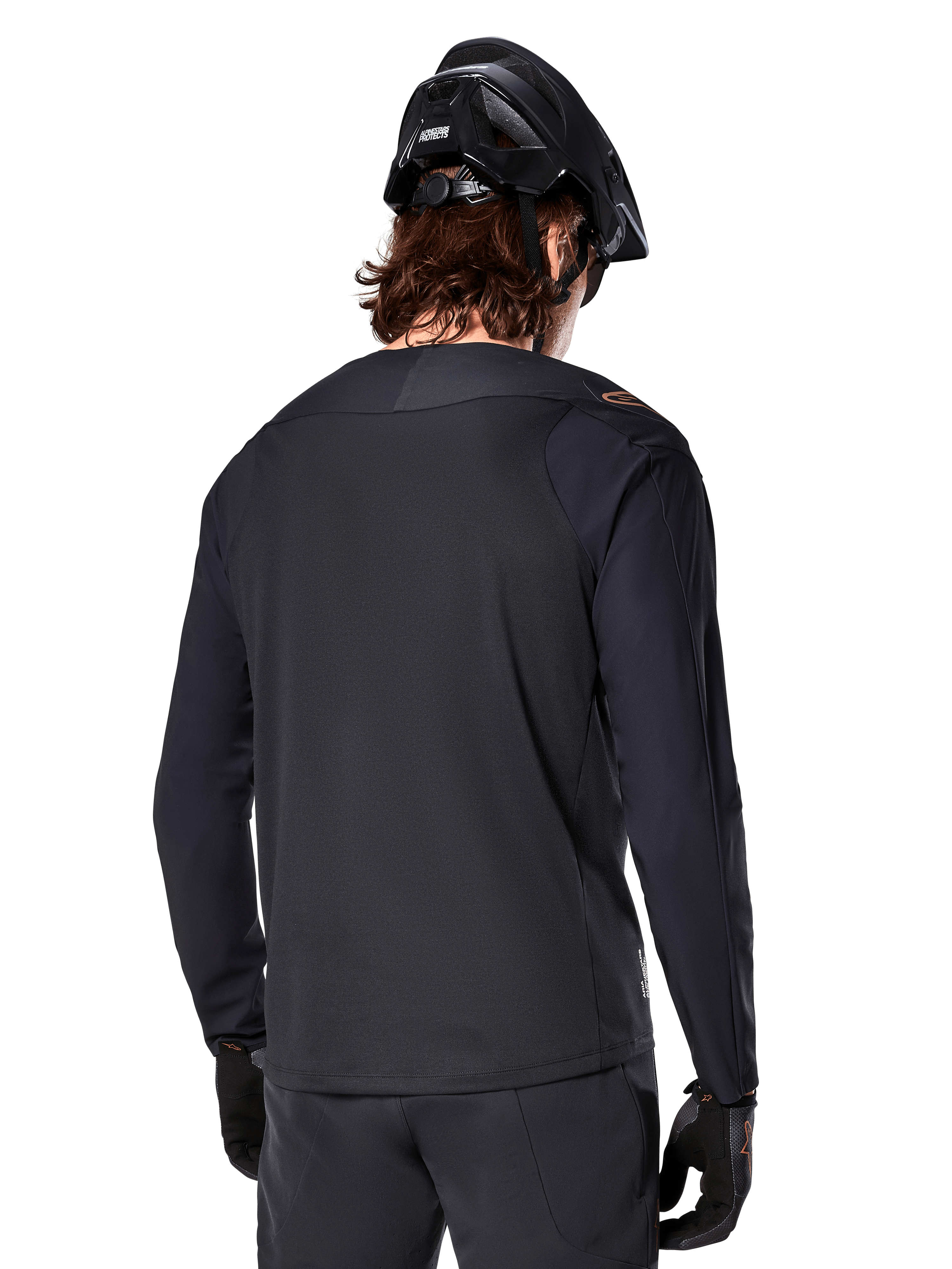 Alpinestars A-Aria Polartec Switch Jersey - Manga Longa, preta, vista de costas, usada com um capacete de BTT e luvas pretas, apresentando um design de cauda longa para desempenho fora de estrada
