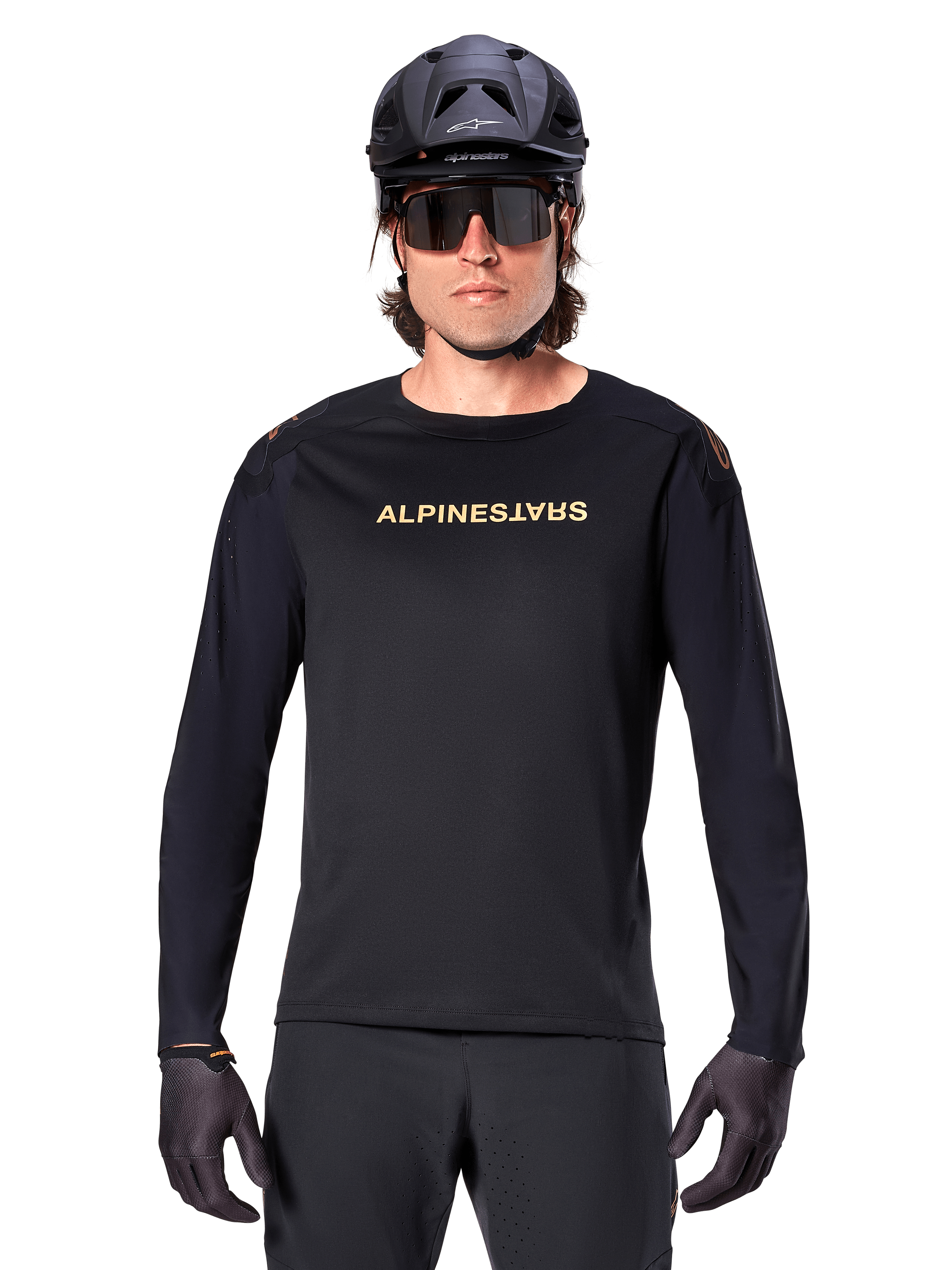 Jersey de Manga Longa Alpinestars A-Aria Polartec Switch, preta, logótipo Alpinestars dourado no peito, usada com capacete de BTT preto, óculos de sol escuros e luvas pretas, equipamento profissional para trilhos de mountain bike