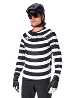 Camisola de Manga Comprida Alpinestars A-Aria Oscar, camisola de ciclismo BTT, riscas horizontais pretas e brancas, usada com capacete preto e óculos de sol, com logótipo Alpinestars no peito, vestuário de performance para BTT